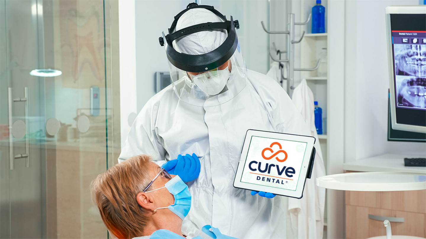 Dentist,In,Coverall,Pointing,At,Green,Screen,Display,During,Coronavirus